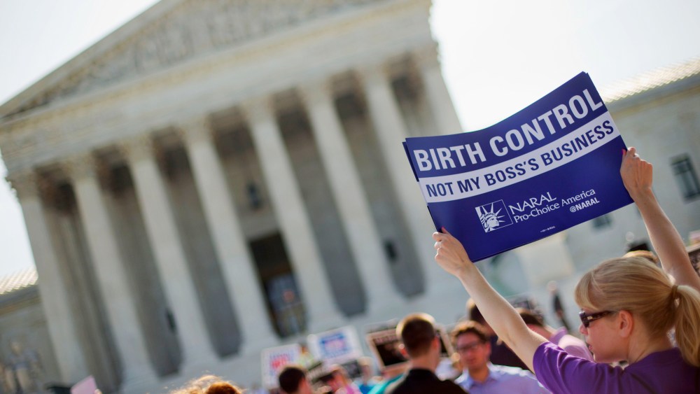 Image: A demonstrator holds up a sign outside the Supreme Court