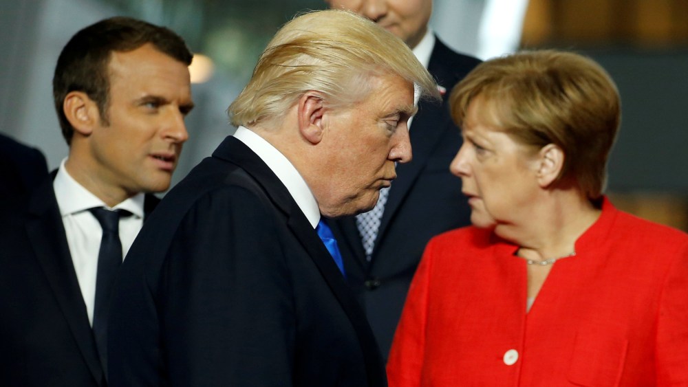 Image: President Donald Trump walks past French President Emmanuel Macron (L) and German Chancellor Angela Merkel on his way to his spot for a family photo during the NATO summit at their new headquarters in Brussels, Belgium, May 25, 2017.
