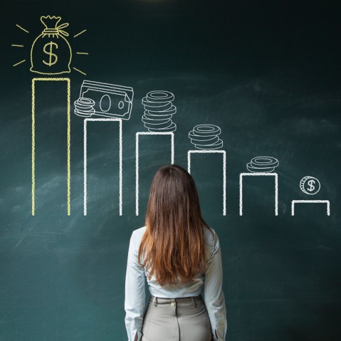 Image: Businesswoman looking at a financial chart on chalkboard