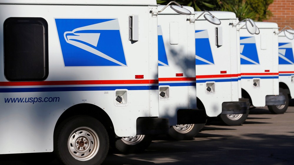 Image: U.S. postal service trucks sit parked at the post office in Del Mar, California
