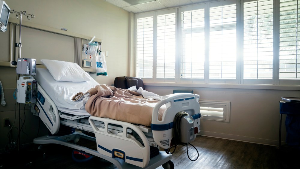 Empty hospital bed near sunny window