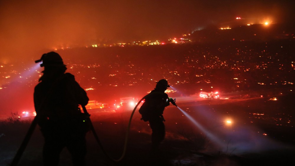 Image: Firefighters walk to the fire line at the Lilac fire in Bonsall, California.