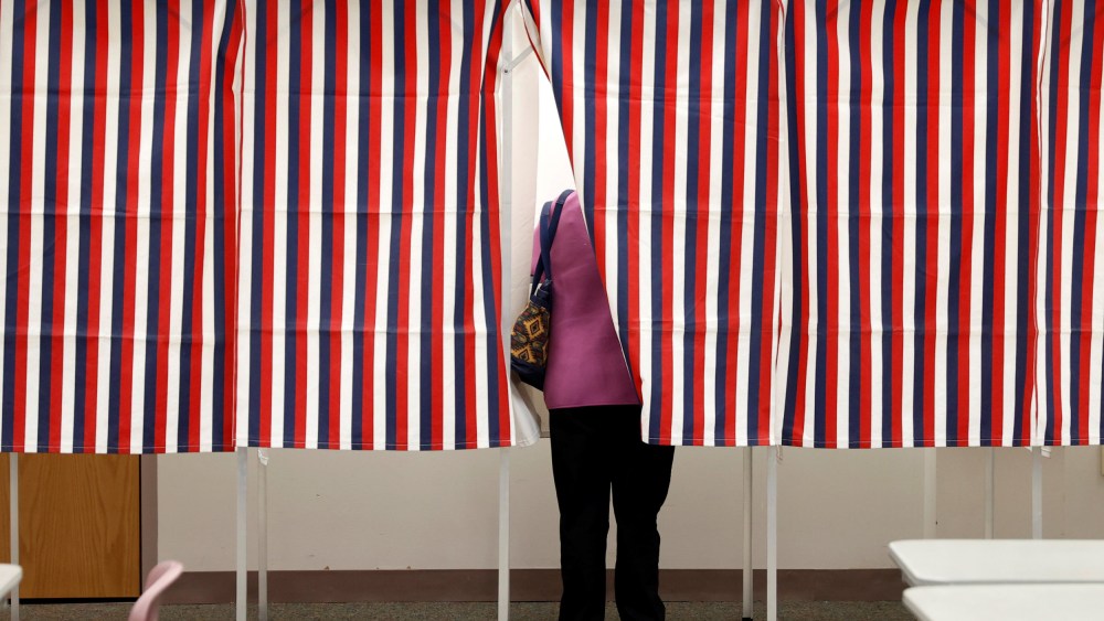 Image: A voter stands in voting booth while voting in the New Hampshire U.S. presidential primary election in Manchester