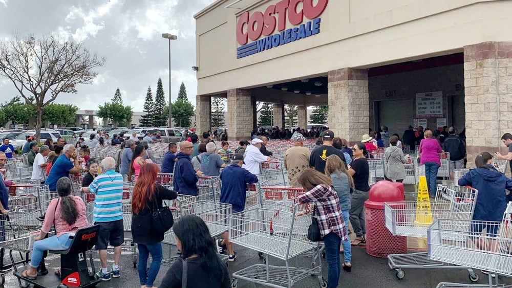 Image: Shoppers in a Costco stock up on a 14-day supply of food, water and other necessities in Honolulu