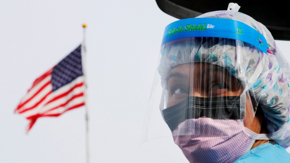 Image: A nurse wears protective gear at a drive-thru coronavirus testing site in Seattle on March 17, 2020.