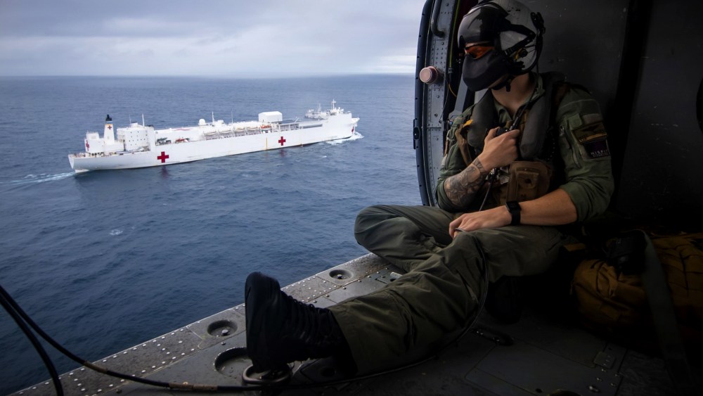 Image: A Naval aircrewman flies in a Seahawk helicopter alongside the USNS Comfort, a hospital ship, in the Pacific Ocean on on June 24, 2019.