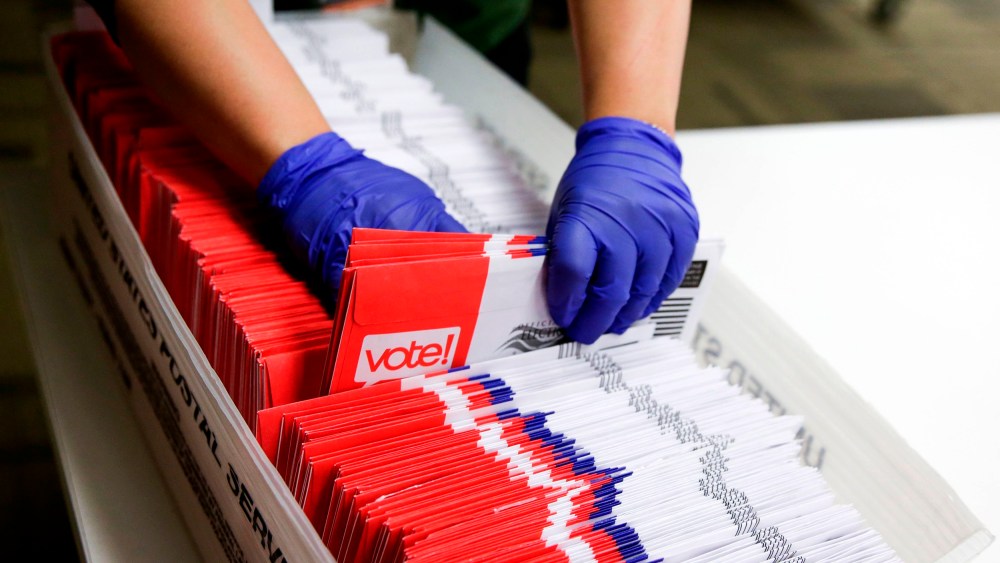 Image: A poll worker sorts vote-by-mail ballots in Renton, Wash., on March 10, 2020.