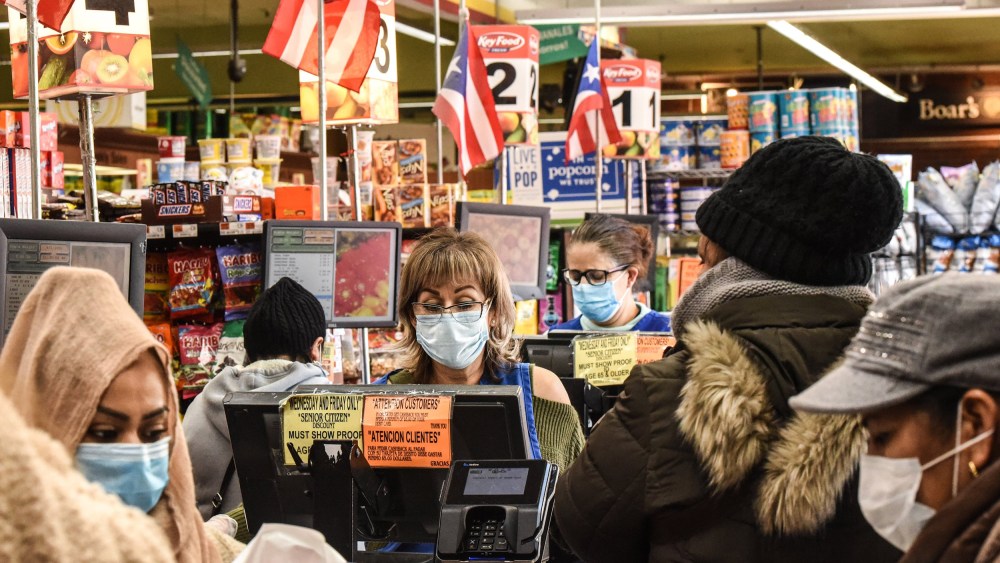 Image: Cashiers wearing protective masks work in a grocery store in the Bushwick neighborhood of Brooklyn  on April 2, 2020 in New York City.