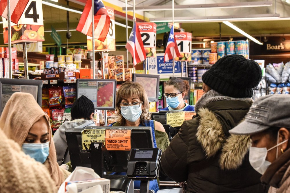 Image: Cashiers wearing protective masks work in a grocery store in the Bushwick neighborhood of Brooklyn  on April 2, 2020 in New York City.