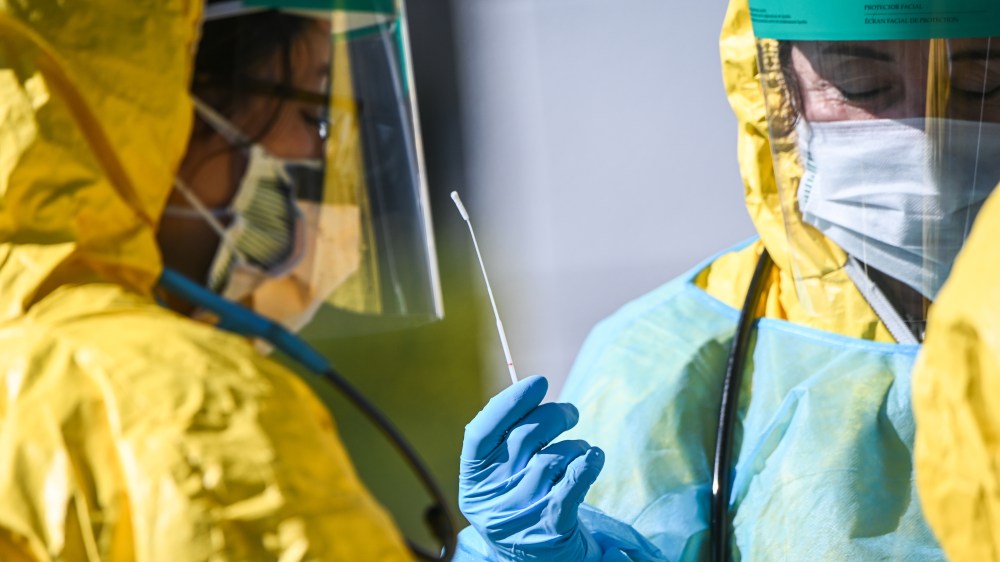 Image; A cotton swab used in a nasal passage as health care professionals test for COVID-19 at a testing site in Jericho, N.Y. on March 24, 2020.