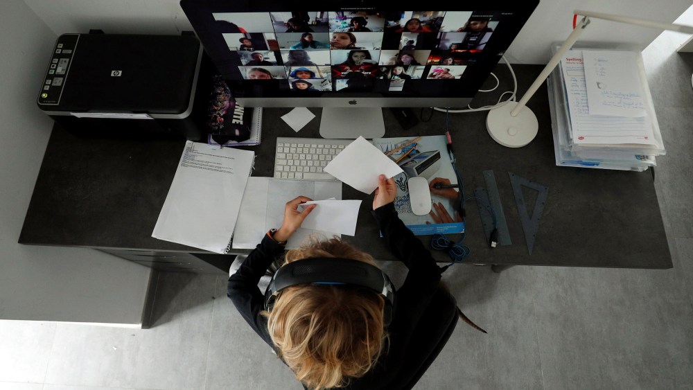 Image: A student takes classes online with his companions using the Zoom APP at home