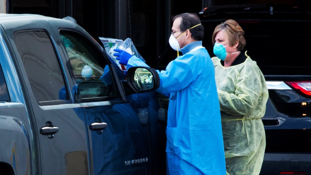 Image: People use a newly approved saliva-based coronavirus disease (COVID-19) test at a testing site in Edison, New Jersey
