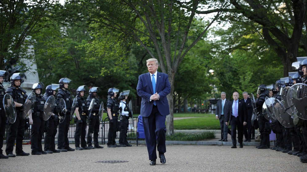 Image: President Donald Trump walks between lines of riot police in Lafayette Park across from the White House after walking to St John's Church for a photo opportunity
