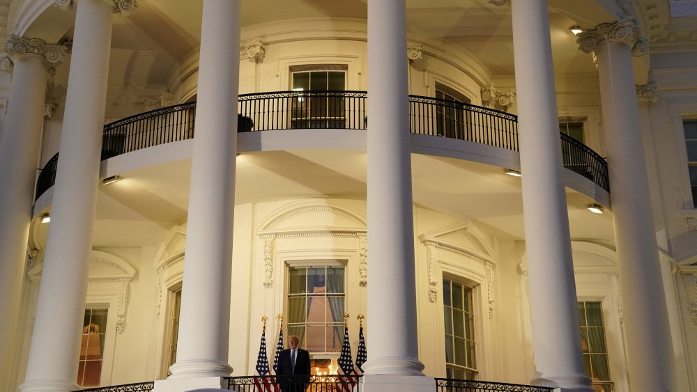 Image: President Donald Trump poses atop the Truman Balcony of the White House after taking off his mask as he returns from the Walter Reed Medical Center,