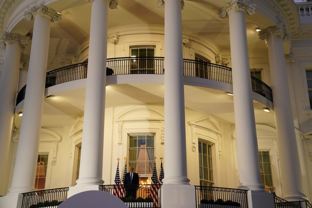 Image: President Donald Trump poses atop the Truman Balcony of the White House after taking off his mask as he returns from the Walter Reed Medical Center,