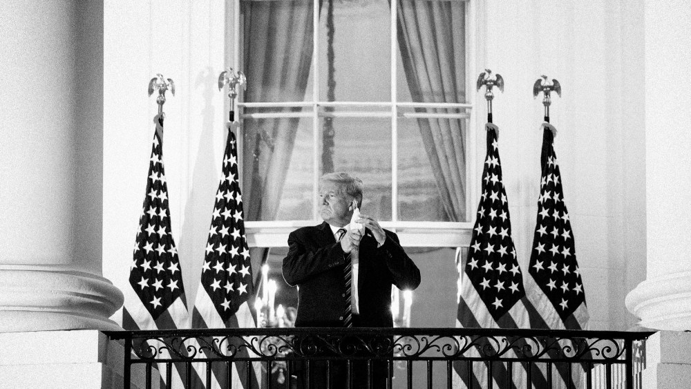 Image: President Donald Trump removes his mask after returning to the White House after receiving treatment for Covid-19 at Walter Reed Medical Center on Oct. 5, 2020.