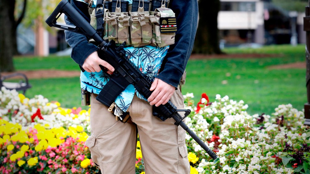 A group tied to the Boogaloo Bois holds a rally as they carry firearms at the Michigan State Capitol in Lansing, Mich., on Oct. 17, 2020.