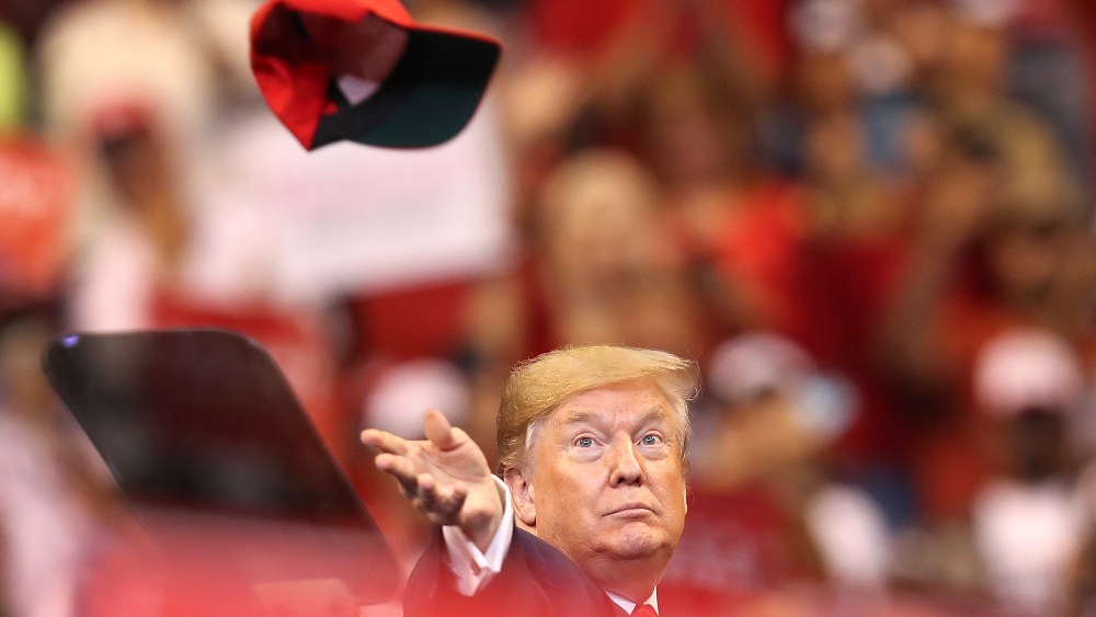 Image: U.S. President Donald Trump tosses a hat into the crowd