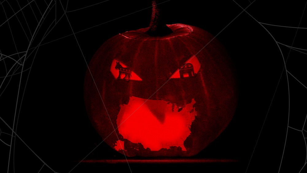 Image: A lit up carved pumpkin with a US shaped mouth and GOP and Democrat symbol shaped eyes.