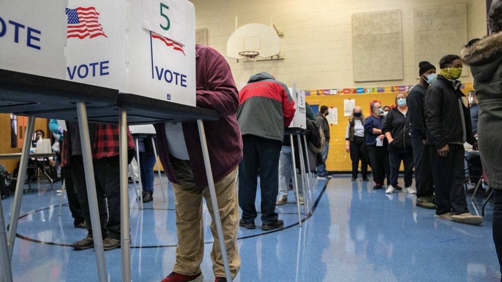 Voters fill out their ballots at a school gymnasium on Election Day in Lansing, Mich.