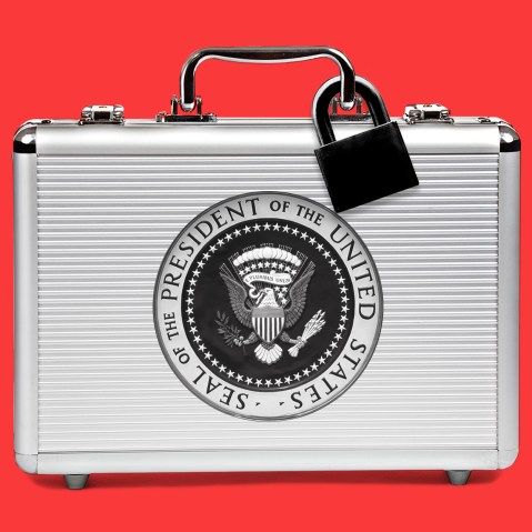 Image: A silver suitcase with a black lock and the seal of the President of the United States sits against a red background