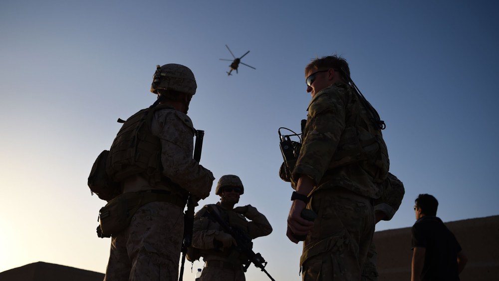 Image: U.S. Marines and Afghan Commandos stand together as an Afghan Air Force helicopter flies past during a combat training exercise at Shorab Military Camp in Lashkar Gah in Helmand province.