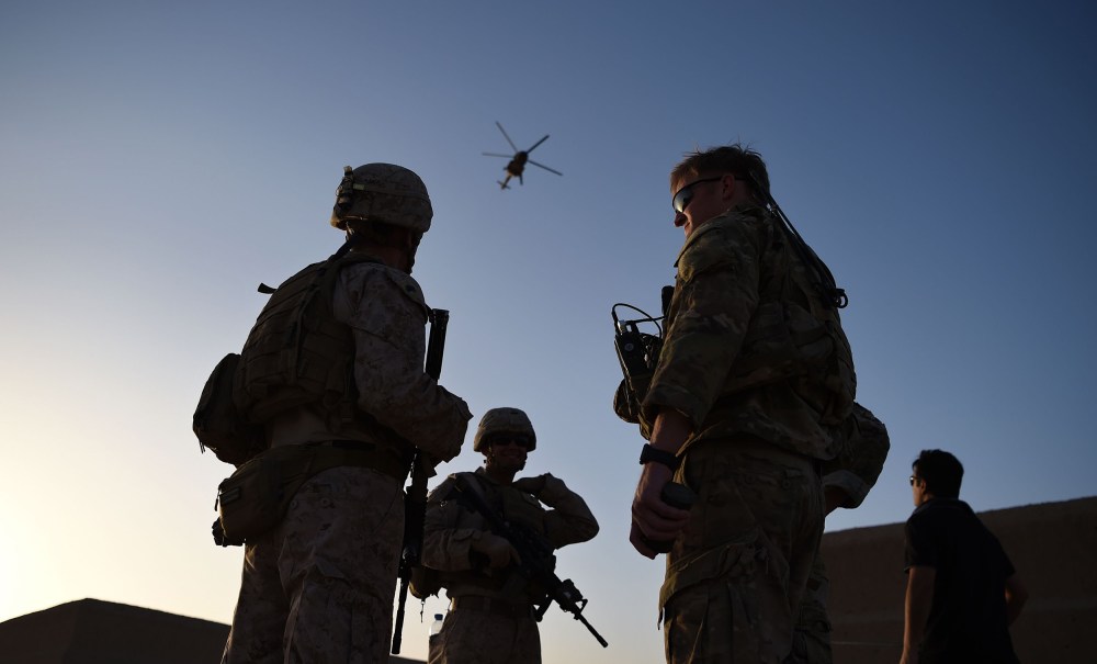 Image: U.S. Marines and Afghan Commandos stand together as an Afghan Air Force helicopter flies past during a combat training exercise at Shorab Military Camp in Lashkar Gah in Helmand province.