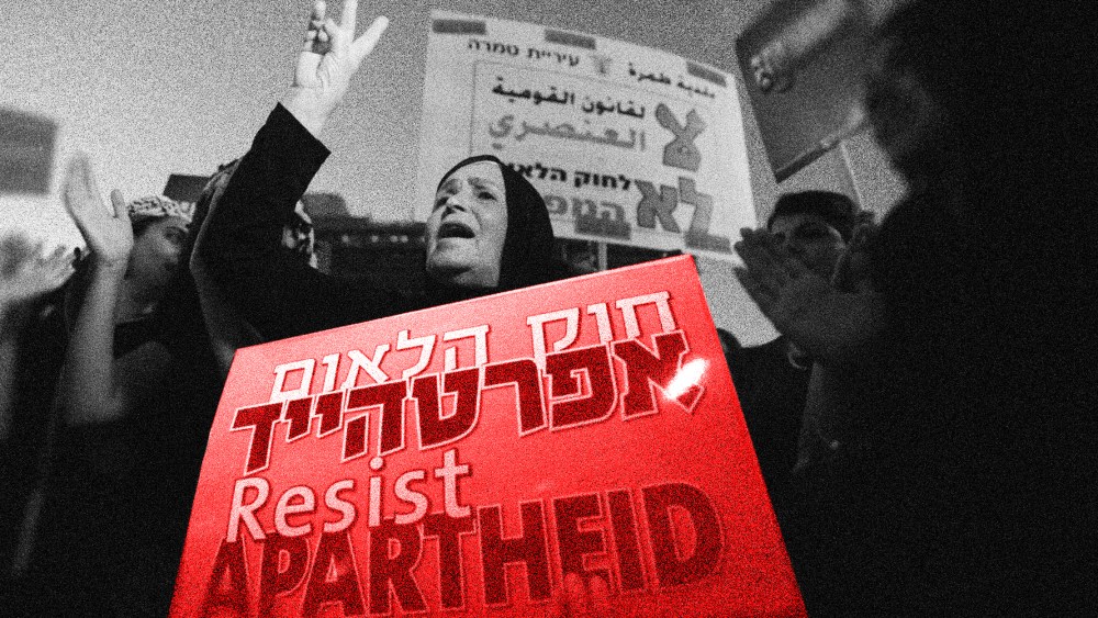 Image: A woman shouts and holds a protest sign that reads 'resist apartheid' in English and refers to apartheid laws in Hebrew...."