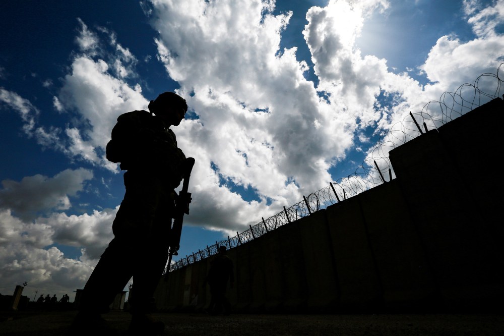 Image: U.S. soldiers stand guard at the K1 Air Base near Kirkuk in northern Iraq, during its handover ceremony