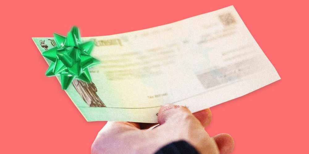 Image: A person holds a U.S. Treasury Check with a green Christmas bow on it.