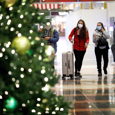 Holiday travelers wearing face masks are seen at Ronald Reagan Washington National Airport in Arlington, Va., on Dec. 23, 2020.