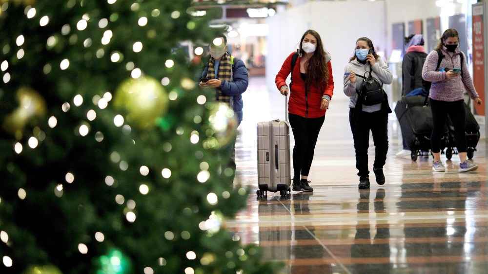 Holiday travelers wearing face masks are seen at Ronald Reagan Washington National Airport in Arlington, Va., on Dec. 23, 2020.
