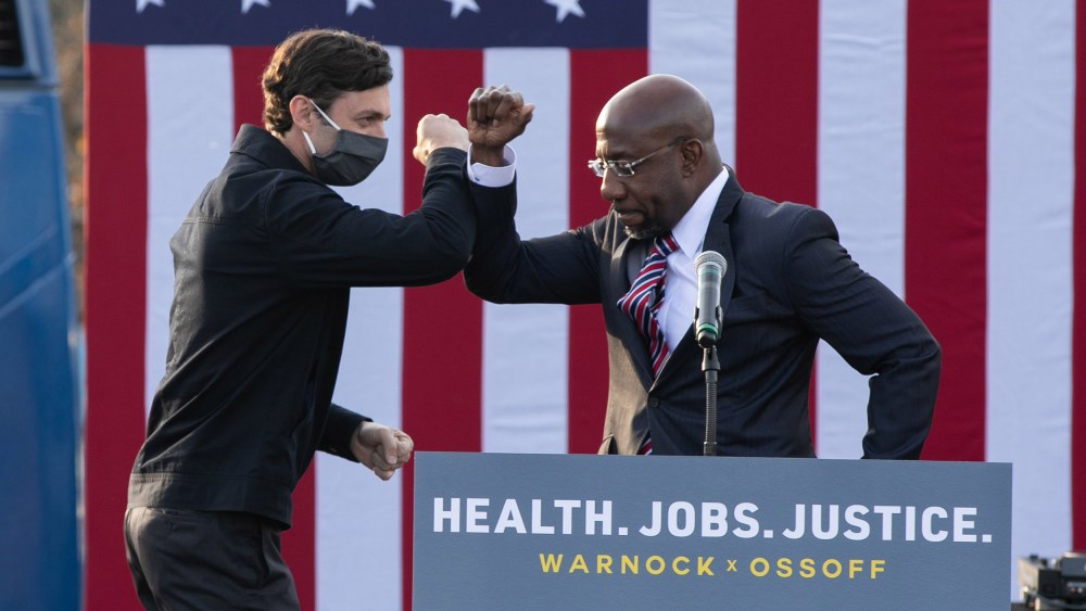 Image: Georgia Democratic Senate candidates Raphael Warnock and Jon Ossoff bump elbows during a "It's Time to Vote" drive-in rally