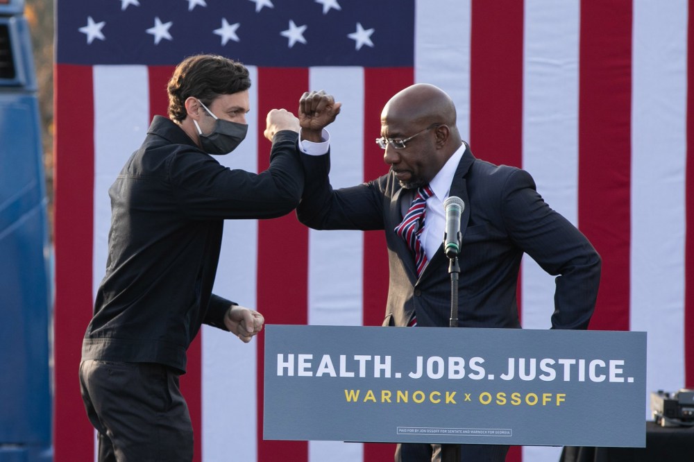 Image: Georgia Democratic Senate candidates Raphael Warnock and Jon Ossoff bump elbows during a "It's Time to Vote" drive-in rally