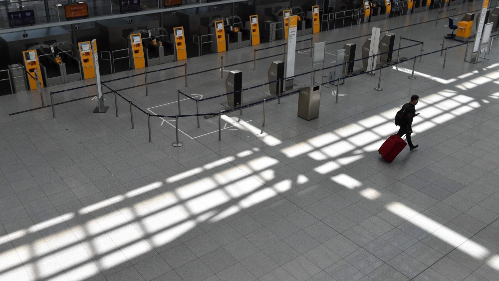Image: A passenger walks in an empty terminal at the "Franz-Josef-Strauss" airport in Munich
