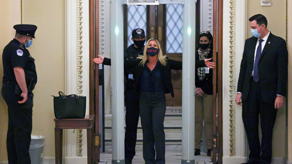 Image: U.S. Representative Marjorie Taylor Greene (R-GA) goes through a new metal detector to enter the House floor in Washington