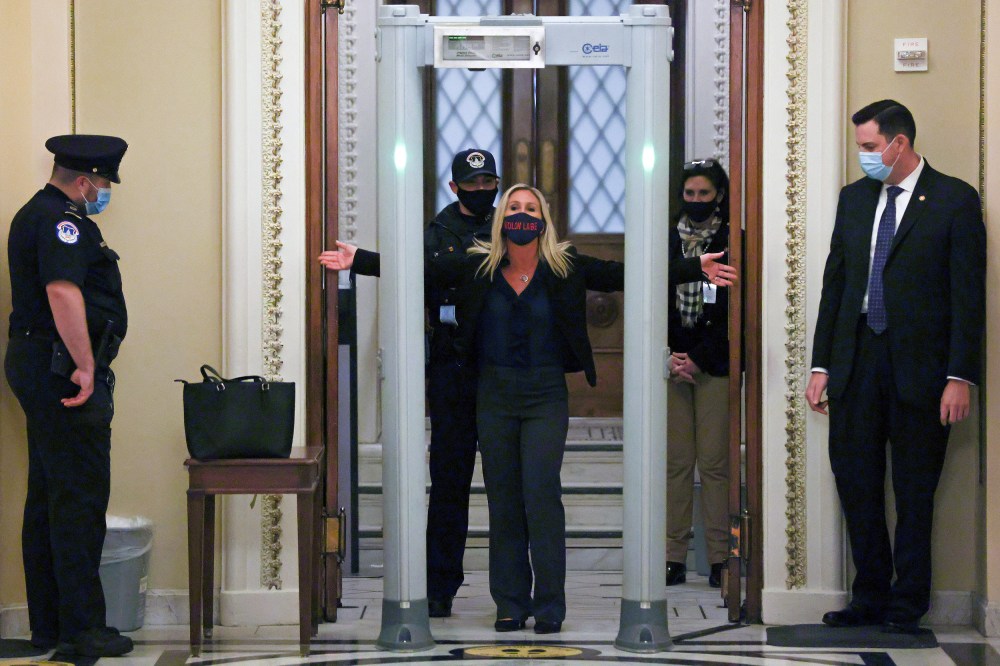 Image: U.S. Representative Marjorie Taylor Greene (R-GA) goes through a new metal detector to enter the House floor in Washington