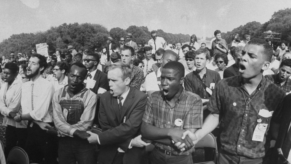 Image: Group of people holding hands during a civil rights rally in front of the Washington Monument.