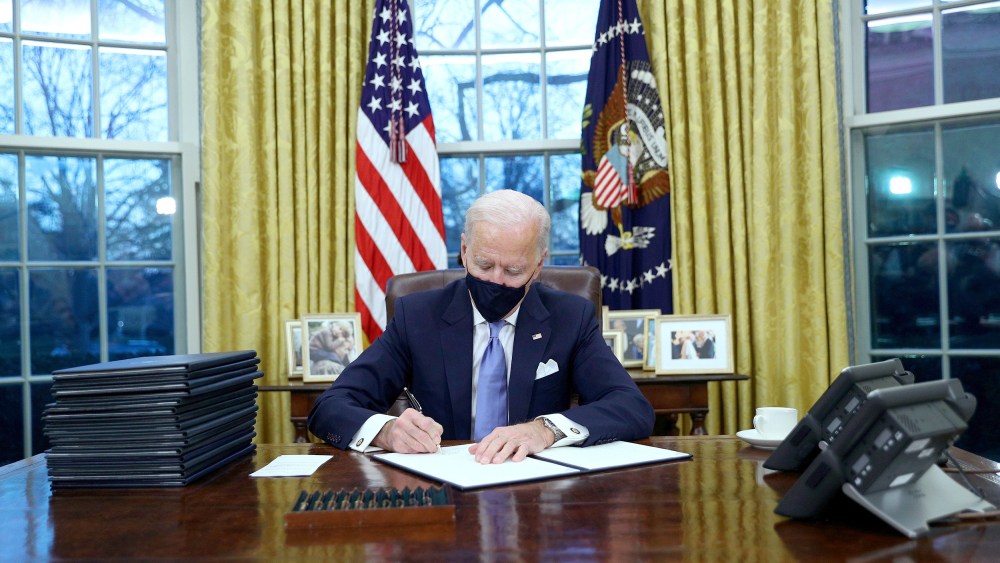 Image: President Joe Biden signs executive orders in the Oval Office of the White House in Washington, after his inauguration as the 46th President of the United States