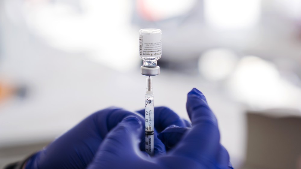 A healthcare worker prepares a dose of the Pfizer-BioNTech Covid-19 Vaccine at a mass vaccination site at The Forum arena in Inglewood, Calif., on Feb. 26, 2021.