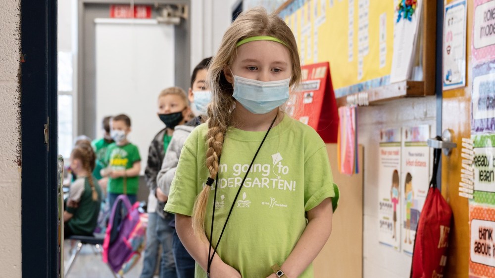 Image: Masked students wait in a socially distanced single file line before heading to the cafeteria at Medora Elementary School on March 17, 2021 in Louisville, Kentucky. Today marks the reopening of Jefferson County Public Schools for in-person learning