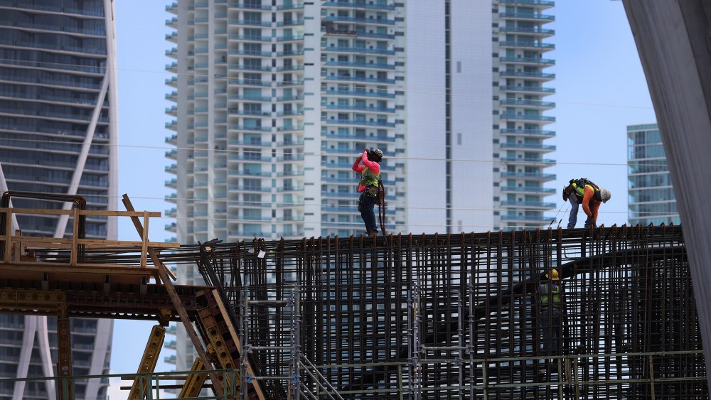 Image: Construction workers build the 'Signature Bridge' replacing and improving a busy highway intersection at I-95 and I-395 in Miami, Fla.