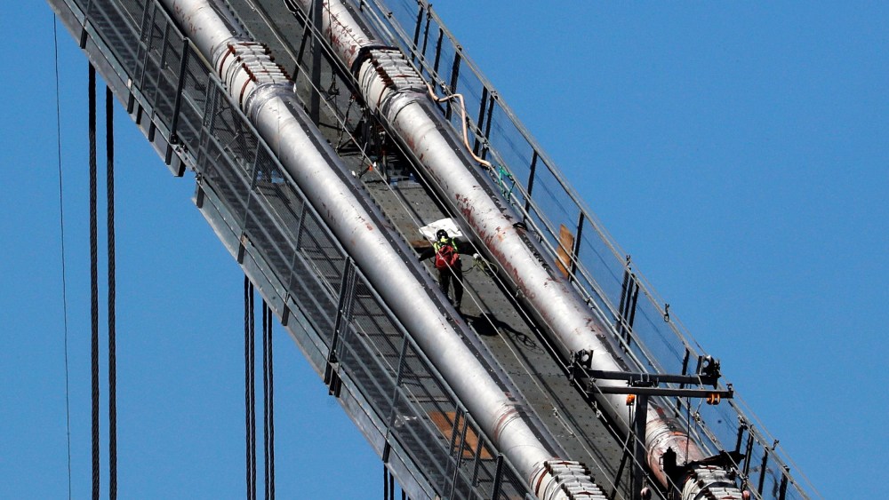 Image: A construction worker scales the northeast cables of the George Washington Bridge duering reconstruction in New York