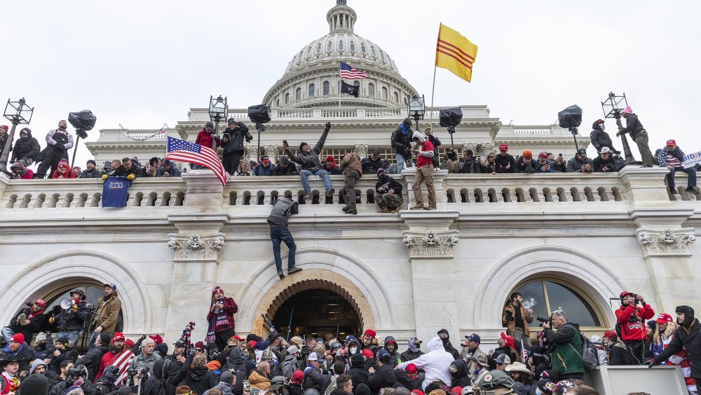 Image: Protesters climb over Capitol building where pro-Trump supporters riot and breached the Capitol,