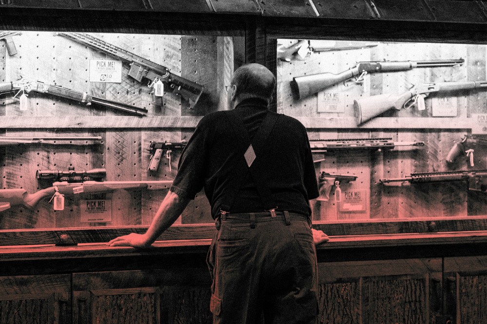 IMage: A man looks at a case of firearms at the National Rifle Association convention in Indianapolis in 2019.