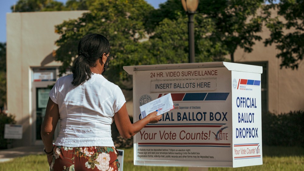 IMage: A woman puts a ballot in a drop box in West Palm Beach, Fla., on Nov. 1, 2020.