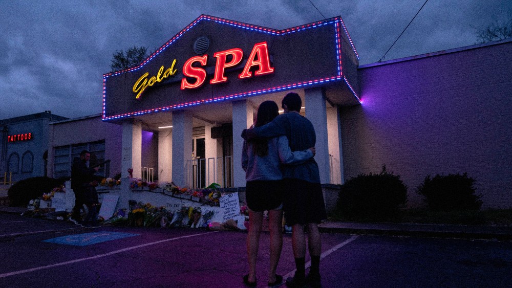 Image: Graham Bloomsmith and Cynthia Shi hug outside of Gold Spa, where four women were fatally shot, in Atlanta on March 18, 2021.