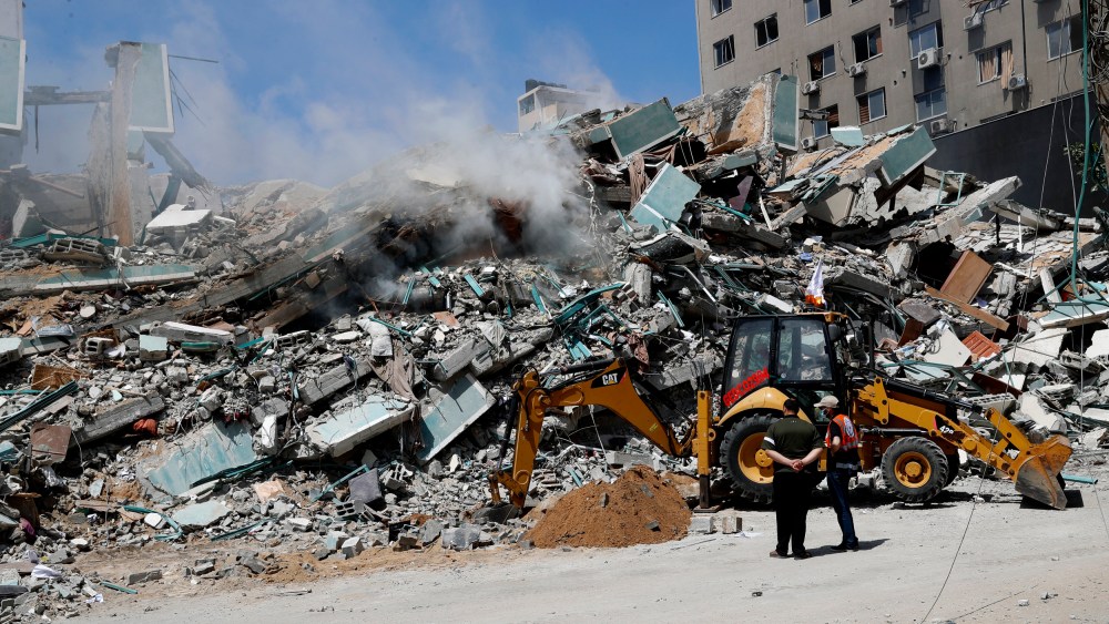 Workers clear rubble from a building that was destroyed by an Israeli airstrike on Saturday that housed The Associated Press, broadcaster Al-Jazeera and other media outlets, in Gaza City on May 16, 2021.
