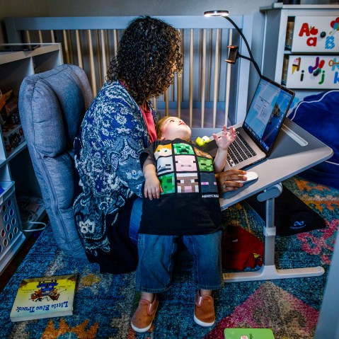 Image:; A mother works at her make shift office set up in her daughter nursery.