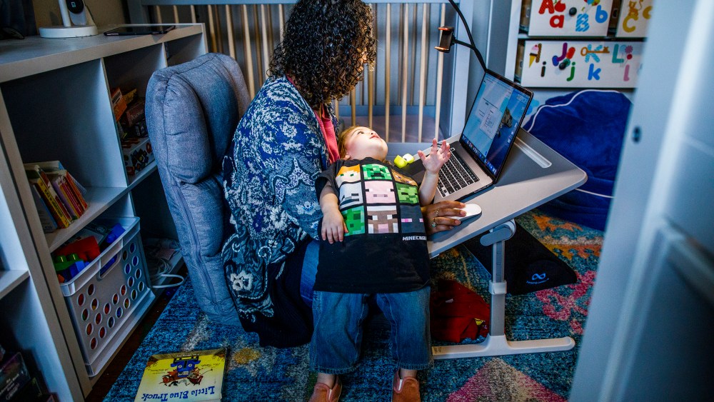 Image:; A mother works at her make shift office set up in her daughter nursery.
